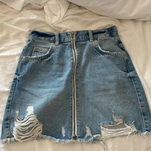 Jeanskjol med slitningar från gina tricot i storlek 34 - En jätte fin kjol från gina tricot med snygga slitningar längat ned. Säljer den för att den är för thight för mig. Köptes för 299kr