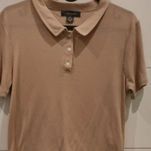 Beige t-shirt/croptop - Beige t-shirt/croptopp från Primark i storlek M 💛Oanvänd. Frakt tillkommer 💕