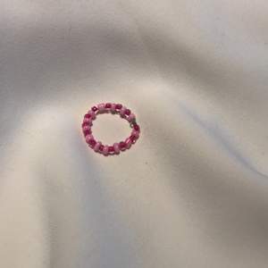 En ring i steerling silver med olika nyanserade rosa pärlor.                   stl: S.                                                      Smycket är Nickel fritt, Bly fritt och Kadium fritt🥰