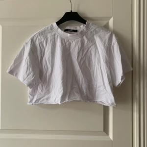 Vit croppad tshirt - Vit croppad tshirt ifrån bikbok, använd 1 gång, är lite skrynkligt på bilden. 
