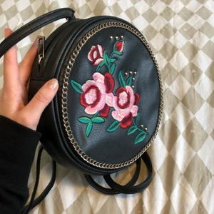 Ryggsäck rund missguided - Supersöt rund liten ryggsäck i fakeläder med broderade rosor. Användt skick.