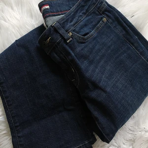 BOOT CUT JEANS - TOMMY HILFIGER - Boot cut-jeans från Tommy Hilfiger i en mörkare blå kulör. Lågt skuren midja och en smickrande passform över lår och stuss.  Använda endast ett fåtal gånger och säljes endast på grund av att jag vuxit ur dem. Önskar dem en ägare som vill ha lika fin relation med dem som jag...