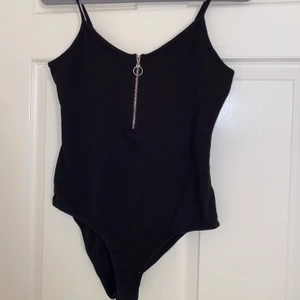 Svart body med silverdragkedja - En svart body med svart dragkedja från fashionnova, oanvänd, liten i storleken.