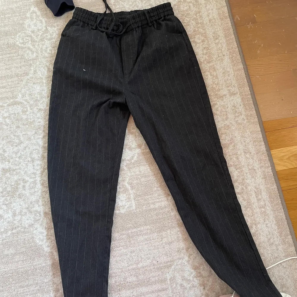 Svarta kostymbyxor säljes! Har gråa ränder och snörning i midjan. Säljes då de är för stora ❤️. Jeans & Byxor.