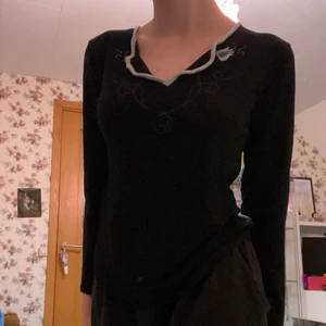 svart topp med blommor  - superfin svart topp med ursnygga blommor i ”kragen” och JÄTTEMYSIGT tyg