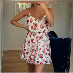 super söt sommarklänning  - Vit sommarklänning med rosa/gröna rosor. Reglerbara band & resår i midjan. Använd 2 gånger, köpt i New York på Forever 21. Frakt ingår i priset!