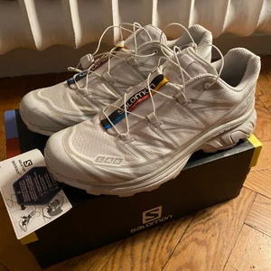 Vita Salomon skor - Säljer mina vita Salomon XT-6 sneakers. Använd ca 3 gånger, annars helt nya med kartong. Samma som Bella Hadid har. Slutsålda överallt. Storlek 41 1/3 passar upp 40-42