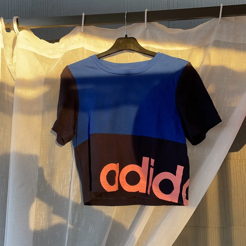 En svart och mörk blå adidas t- shirt☺️använd 1-2 gånger, nu köpt! Rosa text på fram sidan👍🏻💕. T-shirts.