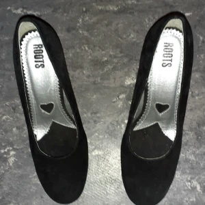 ROOTS svarta mocka pumps nyskick str39 - Snygga mocka pumps av märket ROOTS. Använd 2 ggr som nyskick. Klack ca 7 cm. Nypris 599kr. Skön på foten.