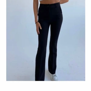 Design By Si kostymbyxor - Helt nya och fina svarta utsvängda kostymbyxor från Design By Si. Dem är aldrig använda och lappen sitter kvar på. Dem är i storlek xs och på hemsidan heter dem ”Flare pants high waist” om du vill kolla mer på dem där. Skulle säga att dem är lite längre i modellen. Om du är osäker om dem kommer vara för långa/korta så kan du bara kontakta mig.Köpte dem för 405 kronor och säljer för 300kr exklusiva frakt‼️Bild 1 och 2 är lånade från deras hemsida‼️Buda ENDAST om du kan köpa den för priset du budar!