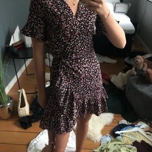 Wrapklänning leopard  - En mini wrapklänning med volanger k rosa/lila leopard mönster. 