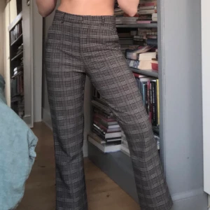 Rutiga kostymbyxor - Säljer dessa snygga ruta kostymbyxor med lite utsvängda ben. De är i storlek 34. Säljer då de inte kommer till användning! 100kr+frakt. 