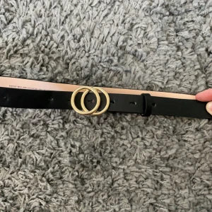 Skärp med guldiga ringar - Ett skärp som är super bra att ha ett Jens! 