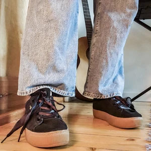 Puma skor - Svarta Puma skor med brun platform sula. Storlek 41. Skosnörena är i siden, de har vikt sig lite men går att stryka så de blir platta igen. Lite slitna i hälarna bara, annars är de i bra skick. 