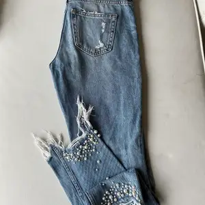 Jeans ifrån hm, med pärlor och fransar vid benslutet, stl 25