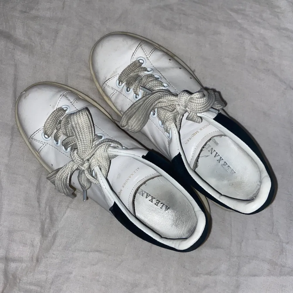 Sneakers från Alexander McQueen, vita med svart mocka på hälen. Väl använda, men sjukt sköna och har definitivt ett par säsonger kvar. . Skor.