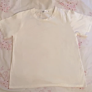 Enkel vit kortärmat topp - Toppens längd är 59 cm och armlängd är 20 cm. Jag har köpt toppen för 3 år sedan men det är oanvänd. Plagget kommer att blir nytvättad och stryka innanför leverans. Skriv om ni vill ha fler bilder eller frågor om plagget.