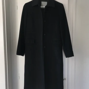 Kappa klassisk svart second hand - Kappa köpt second hand och i riktigt fint skick. Skräddarsydd med lite markerad midja i en klassisk modell. Behöver tyvärr inse att den blivit för liten. Skulle säga att den passar storlek xs och s. 