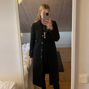 Kappa - Svart kappa från Na-Kd x Misslisibell i storlek 34. Slutar precis nedanför knäna på mig som är 174 och den har ett bälte i midjan som stängs med knappar. Säljer då den är för liten för mig💗