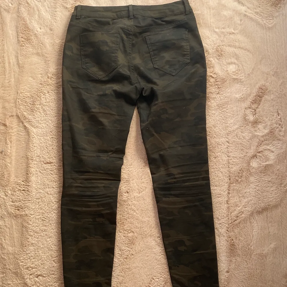 Mörkgröna camoflage byxor i strecight material från zara som är lågmidjade med dragkedja fickor på sidorna . Jeans & Byxor.
