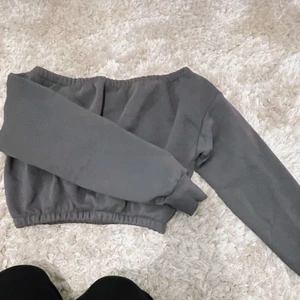 Sweatshirt  - En off shoulder croppad sweatshirt från Nelly. Mörk grå i storlek xs. Resår både uppe vid axlarna och i midjan.
