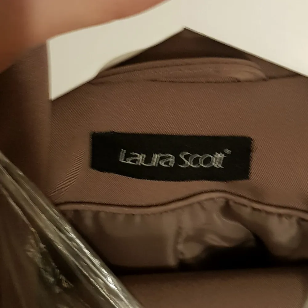 Märke Laura Scott, brun kostym, kavaj med byxa och kjol, Storlek Small, byxor 36 med innermått ben ca 72cm. Kostymer.
