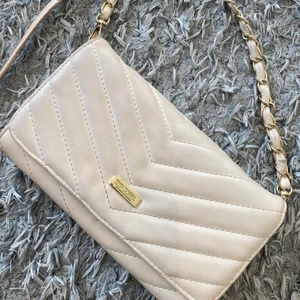 Vit guld väska - Vit väska med guld detaljer. Väl använd och därav priset. Den är vitare i verkligheten, bilden fick den och se smutsig ut.