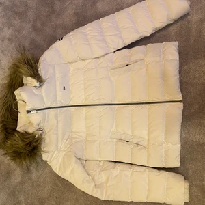 Tommy Hilfiger jacka - Vit jacka från tommy hilfiger. Använd en vinter för något år sedan. Nedre baksida är lite missfärgad av svarta jeans, vilket kanske kan tas bort i tvätt. OBS vet ej vad frakten kostar.