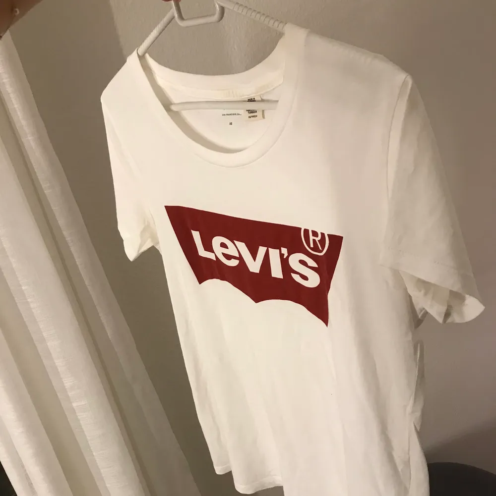 Vit Levi’s t-shirt med röd logga. Är i mycket bra skick. Kan mötas upp eller frakta.. T-shirts.