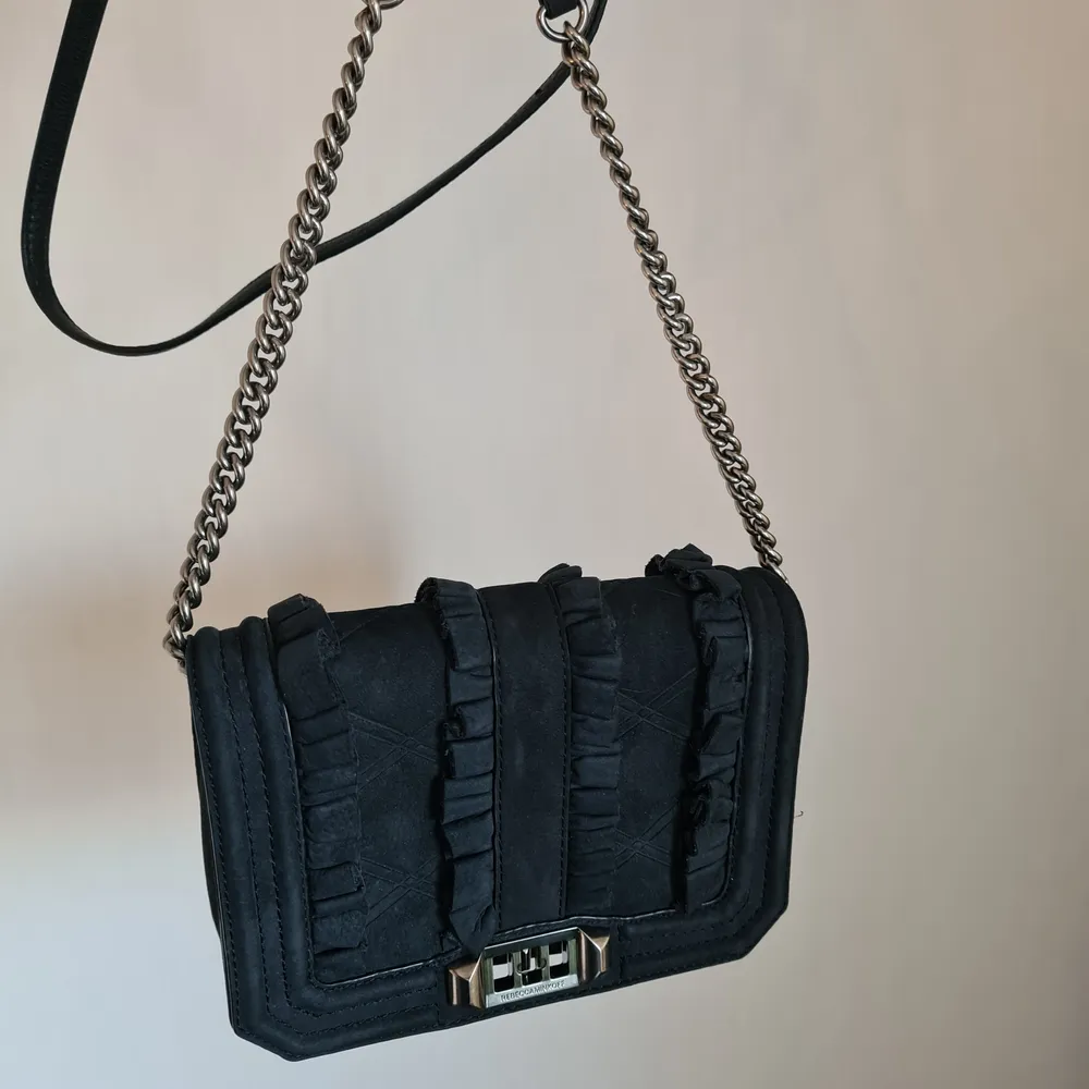 En axelremsväska från Rebecca Minkoff i äkta skinn och läder. En lång rem i läder och kedja som går att justera. Fint skick, knappt använd. Nypris ca 2000 kr. Ganska så liten, ca 20x15 cm. Förvaringspåse som väskan alltid förvarats i medföljer. Kan skickas spårbart för 66 kr.. Accessoarer.