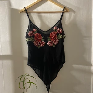 Svart body med blommor - Svart genomskinlig body med blommor! Suupersnygg verkligen men använder aldrig, frakt tillkommer!🖤✨