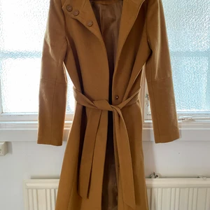 Kappa - Världens finaste kappa i perfekt beige färg som tyvärr inte kommer till användning. Längden passar bra på mig som är 1.56 cm lång. Använd max fem gånger, nypris 999kr på Nelly.com. 