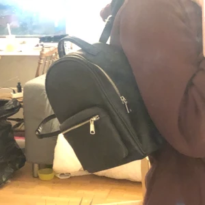 Svart väska - En liten svart ryggsäck. Har justerbara band. Aldrig använd, väldigt bra skick