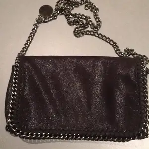 Svart glittrig handväska med kedja som axelrem. Köpt på Miinto