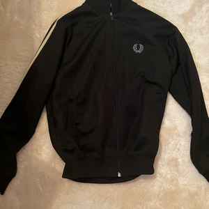 Fred Perry kofta  - Svart Fred Perry kofta som är köpt på second hand. Kommer dessvärre aldrig till användning. Skulle säga att koftan är mer som en S