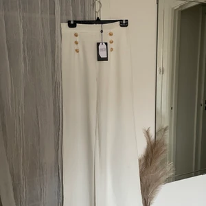 Vita kostymbyxor med guld detaljer  - Oanvända kostymbyxor i storlek 10 