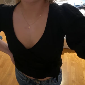 Kortärmad topp - En svart kortärmad tröja med knytdetaljer nedtill så man kan justera hur man vill att den ska sitta😊 