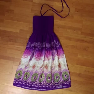 Färgglad lila klänning med mönster - Superfin klänning i fina lila toner, samt vackra mönster. Klänningen knyts runt halsen med två snören. Fin att ha till sommaren, då den går ca. till knäna. Tveka inte att kontakta mig vid funderingar💕