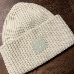 Ljusgrön acne mössa - Ljusgrön acnemössa köpt vintern 2020. Knapps använd. Lite smutsig men går såklart att få bort. Köpt i acne studios butiken på Norrmalmstorg, Stockholm