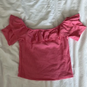 Rosa offshoulder tröja med volanger  - Väldigt rosa tröja som kan bäras antingen som en vanlig T-shirt eller runt axlarna. Köpt i Japan på Zara några år sedativa har inte burits sedan dess pga förlusten storlek.