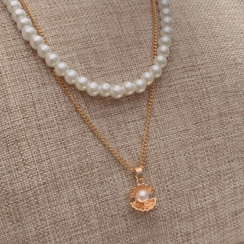Ett halsband med ett snäckskal och en pärla i🐚🌊 Metallen är i ljus guld✨  Matcha med ett pärlhalsband (49kr)🤩. Accessoarer.