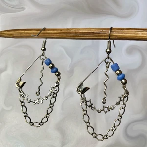 Örhängen - Örhängen gjorda med säkerhetsnålar samt olika kedjor och pärlor! De är 3 cm på bredden och 4,5 cm på längden. Säljer för 50kr + 12kr i frakt🦋🦋🦋