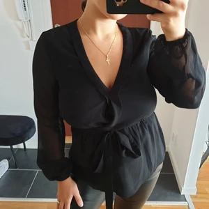 SVART BLUS - En svart blus med knytning i midjan! Använd en gång! Storlek 36! Köparen står för frakten!