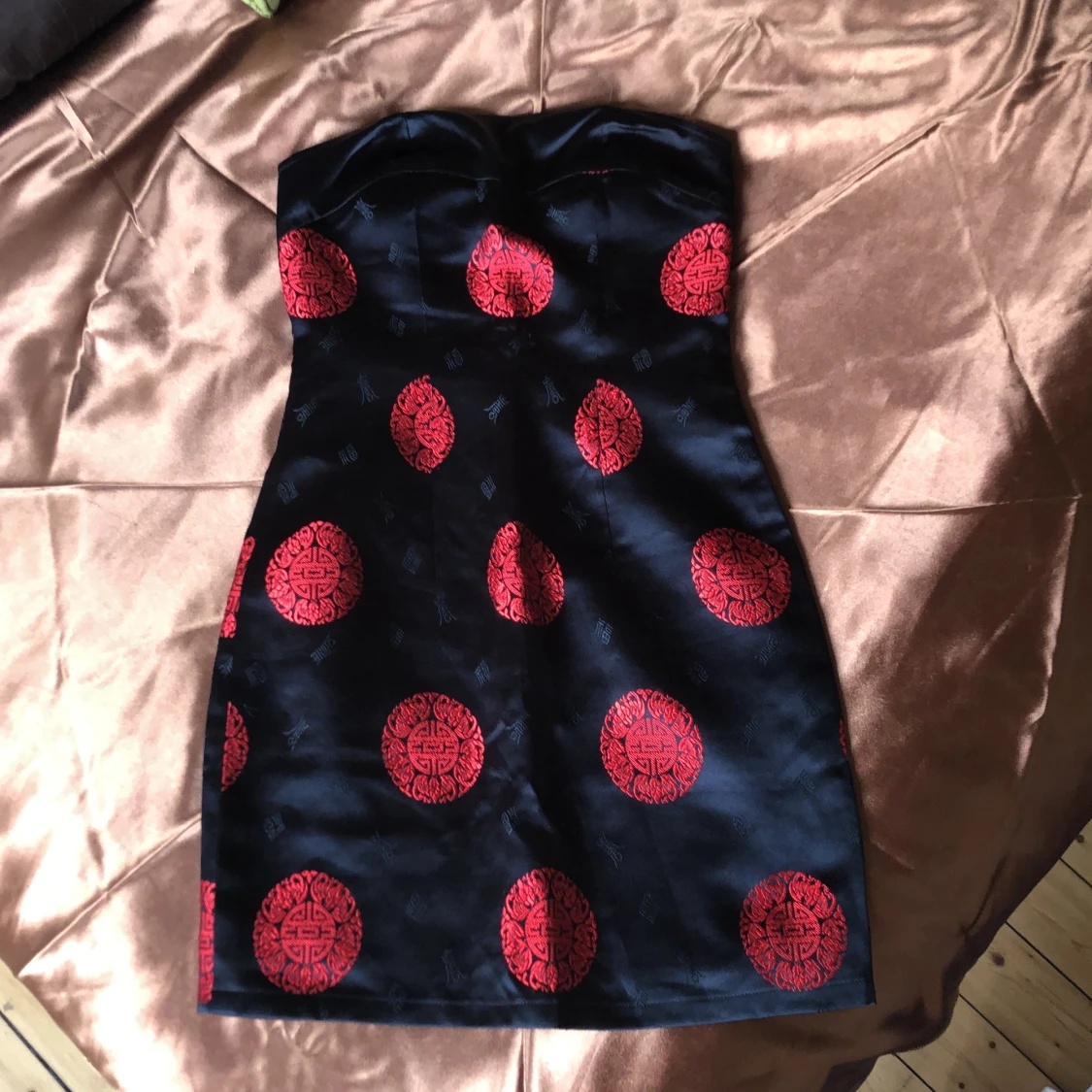 Svart ärmlös klänning med rött mönster  - 90