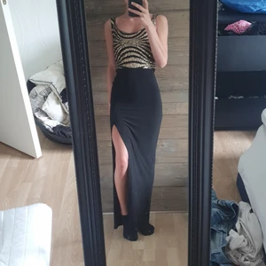 Långklänning  - Festligare långklänning med hög slits på vänster sida och guld paljetter på överdelen🖤 använd 2 gånger.