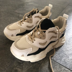 Sneakers Strl 38 - Ett par oanvända sneakers från NAKD med en reflex där bak. Storlek 38. Betalningen sker via Swish, och frakten står köparen för.   Lägsta budet är 120kr