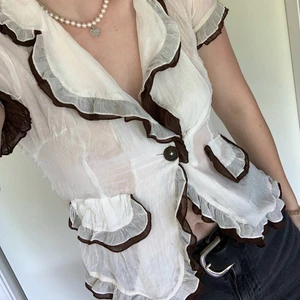 Vit och Brun Mesh Tröja - Säljer denna supersöta och unika topp från Kina❤️ Har lite svårt för att tyda texten men skulle säga att den sitter som XS/S💓 Den är mesh och är därför lite genomskinlig. Knappen har jag sytt på själv då den saknades (går säkert att gör om/bättre)🧚‍♀️