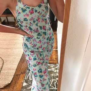 Satinklänning - Turkos/ljusblå satinklänning med blommor, snörning i sidan så man kan justera storleken lite och justerbara axelband✨ helt ny och aldrig använd, perfekt till sommaren!!!💕