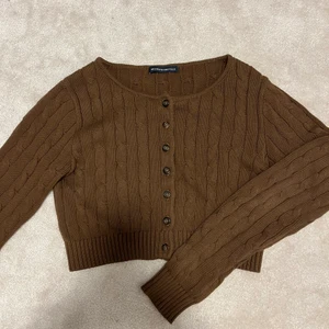 Brun kabelstickad kofta - Brun kabelstickad kofta från brandy Melville🤩🤩 Säljer då den inte kommer till användning, använd 1 gång. Köparen står för frakt 