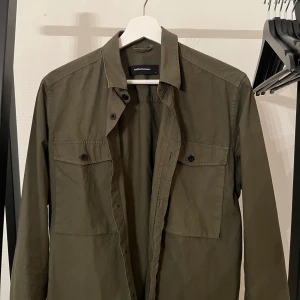 Peak Performance Overshirt - Säljer en mörkgrön Overshirt från Peak Performance, lite tunnare tyg som en stjockare skjorta. knappt använd. Köparen står för frakten. Hör av er vid frågor! Mvh Jacob 